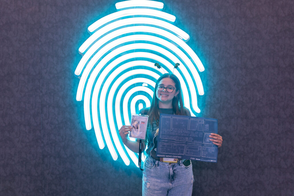 Visitante exibe credencial de recruta oficial e mapa da missão interativa promovida pela Cult SP na gamescom latam.