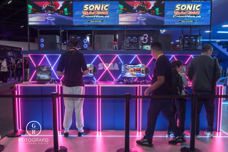 Jogadores testam Sonic Racing no estande da Nuuvem, com iluminação em LED e setup gamer completo.