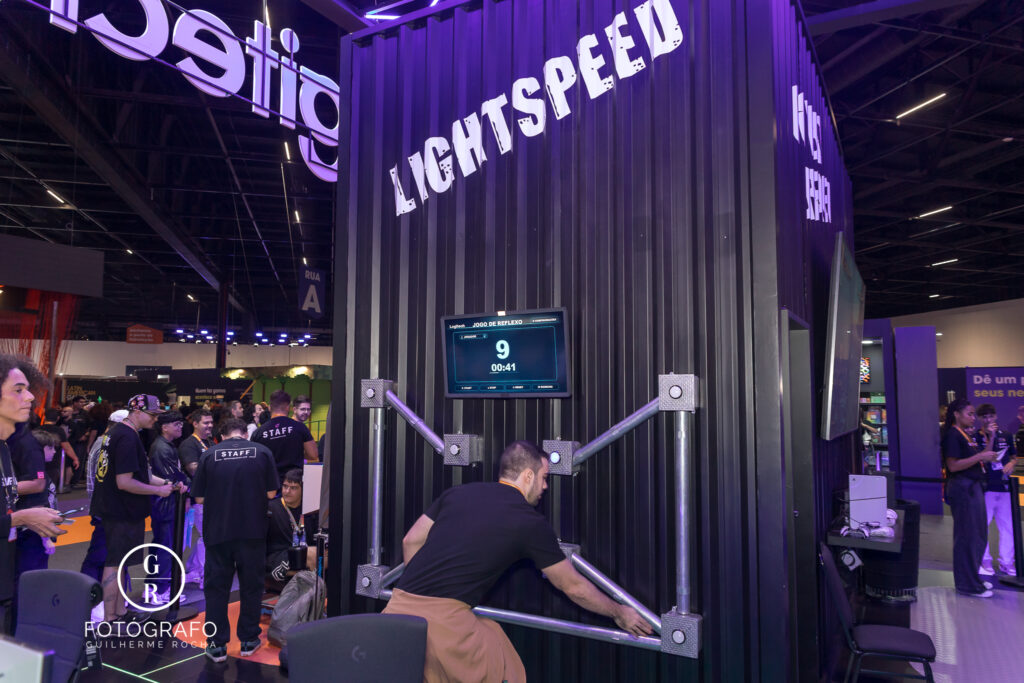 Visitante participa da ativação de reflexo da Logitech durante desafio de velocidade no estande da marca na gamescom latam 2026.