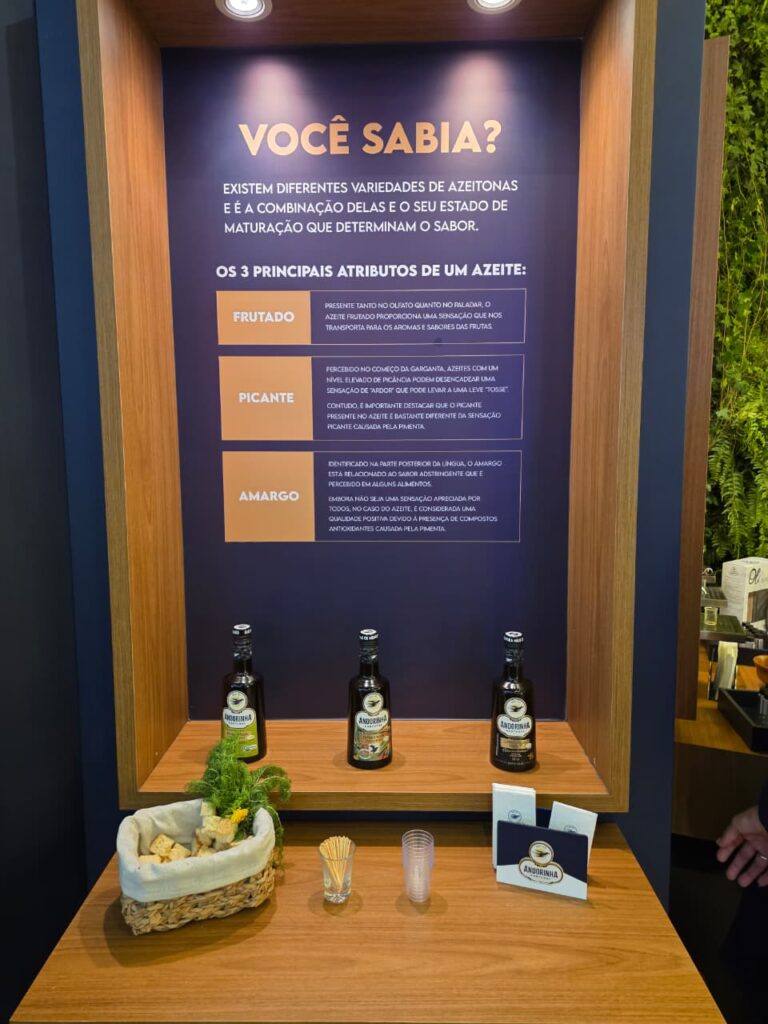 Painel educativo da Andorinha na APAS Show 2026 explica características de azeites extra virgem como frutado, picante e amargo.