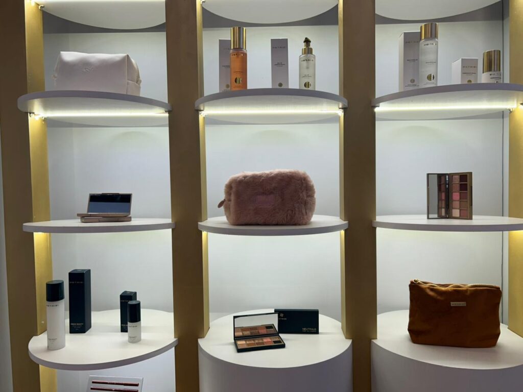 Prateleiras do estande da Petrizzi exibem maquiagens, acessórios e a nova paleta apresentada durante a Beauty Show.
