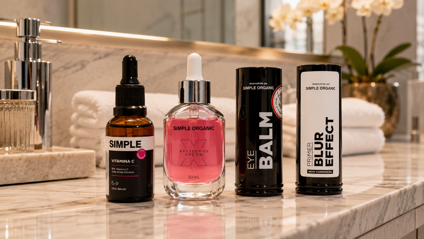 Produtos da Simple Organic organizados sobre bancada de mármore em banheiro sofisticado. A imagem apresenta o Ultra Sérum Vitamina C, Exossomos + PDRN, Eye Balm e Primer Blur Effect em uma composição inspirada em skincare e beleza premium.