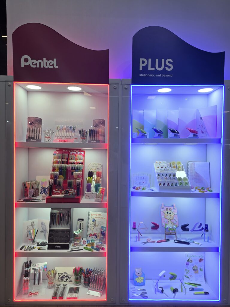 Vitrine da Pentel apresentou canetas, materiais escolares e produtos da marca PLUS em exposição iluminada.