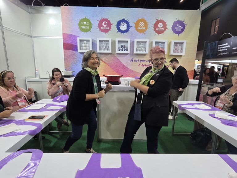 Professoras da Guarany conduzem aula descontraída e animada durante curso prático realizado na Mega Artesanal 2026.