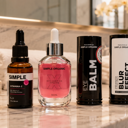 Produtos da Simple Organic organizados sobre bancada de mármore em banheiro sofisticado. A imagem apresenta o Ultra Sérum Vitamina C, Exossomos + PDRN, Eye Balm e Primer Blur Effect em uma composição inspirada em skincare e beleza premium.