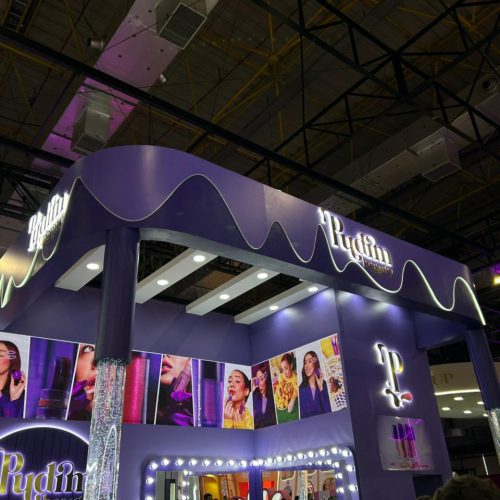 Pudim Beauty apresenta estande temático na Beauty Show 2026 com identidade visual inspirada em sobremesas, iluminação em tons de roxo e espaço dedicado à experiência dos visitantes.