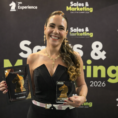 Executiva Alice Urbanetto, CMO da Milky Moo, posa com prêmios durante o Sales & Marketing Executive Summit 2026, destacando reconhecimento no setor de marketing.