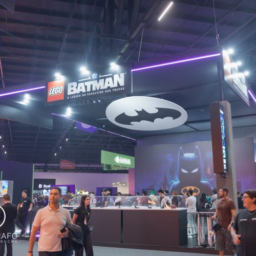 Estande da Warner Bros na gamescom com exposição temática de lego Batman, área interativa e grande logo do herói no teto