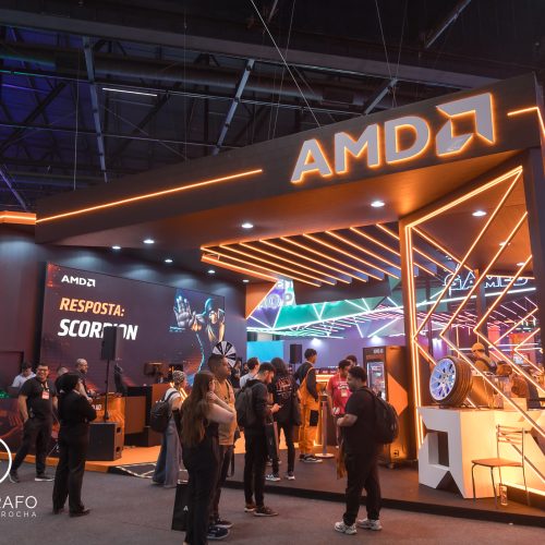 Visão geral do estande da AMD na Gamescom 2026 com iluminação em LED e grande movimentação de visitantes