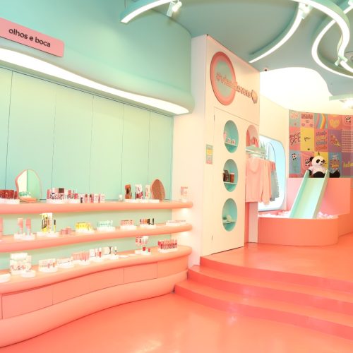 Espaço de maquiagem da flagship da vizzela, com expositores organizados, iluminação moderna e design colorido.