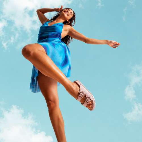 Modelo usando sandália plataforma da Zaxy com vestido azul fluido em ensaio fashion ao ar livre, fotografada em ângulo baixo contra céu azul claro, destacando conforto, leveza e estilo casual da coleção Zaxy.