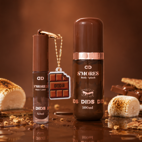Dids apresenta o Gloss Labial S'Mores e o Body Splash S'Mores em uma composição inspirada na clássica sobremesa. A cena reúne chocolate, marshmallows tostados e biscoitos, reforçando a identidade temática da coleção.