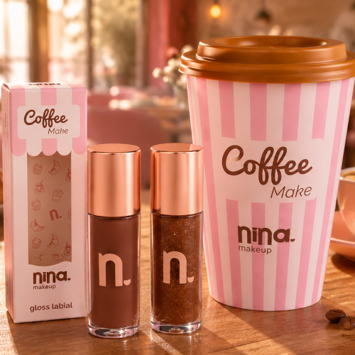 Nina Make Up Coffee Make: glosses Coffee e Latte ao lado do copo temático da coleção em uma cafeteria, com elementos como café, grãos, croissants e macarons reforçando a proposta sensorial da linha.